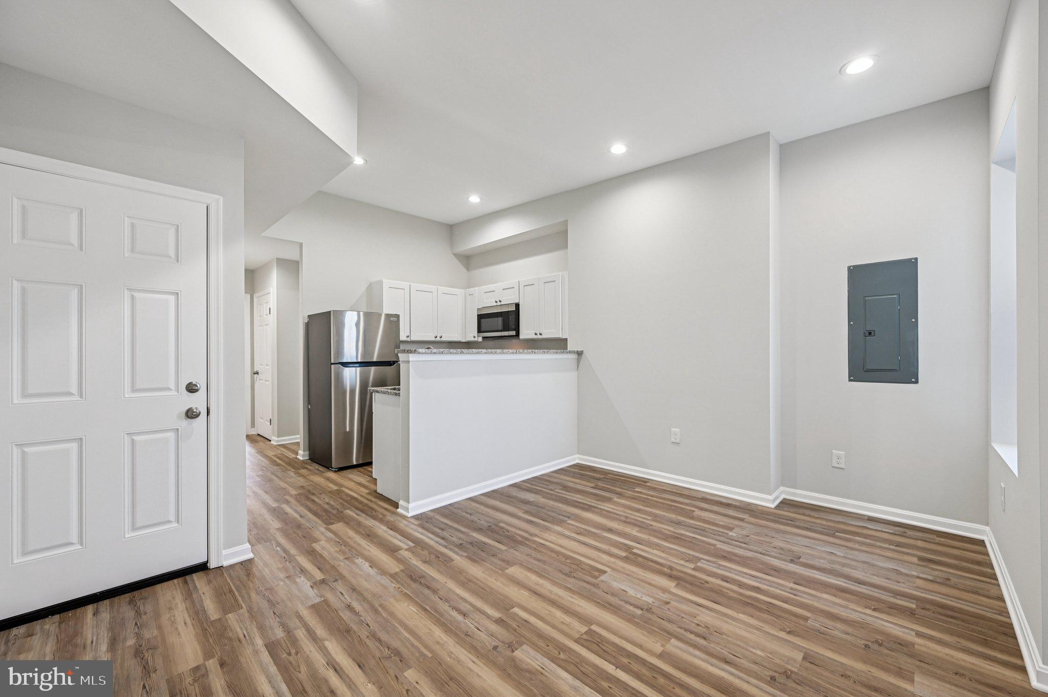 750 Reservoir Street, Unit C Baltimore, MD 21217 - Photo 10 of 25 a view of a kitchen with a refrigerator wooden floor and a window