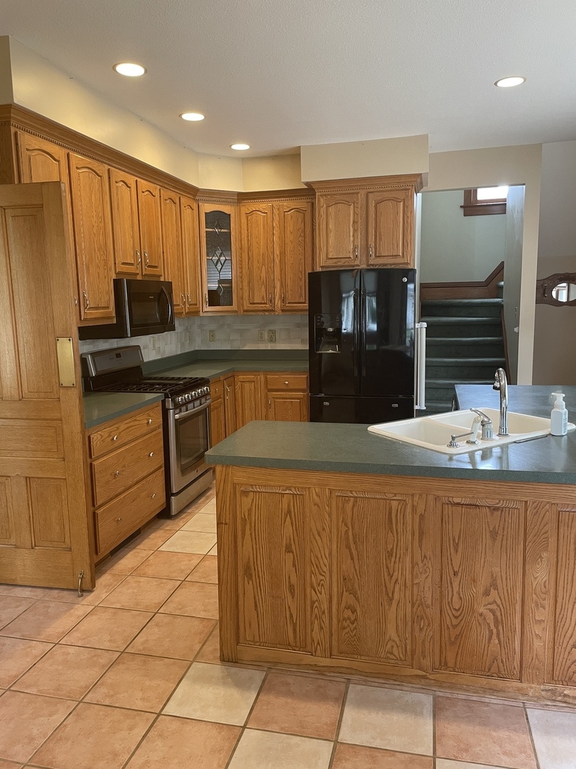 322 Crawford Avenue Dixon, IL 61021 - Photo 21 of 44 a kitchen with stainless steel appliances wooden cabinets a sink and a refrigerator