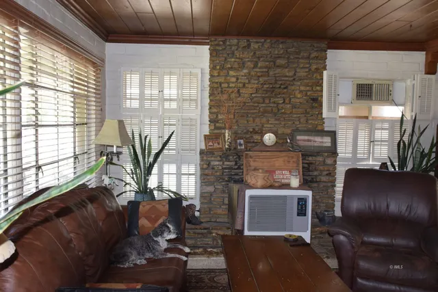 a living room with furniture a flat screen tv and a wall painting