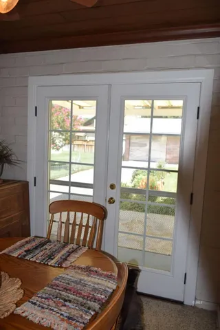 a bed sitting in a bedroom next to a window with chair and table
