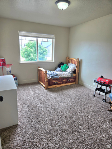 601 West 150 North, Unit 25 Springville, UT 84663 - Photo 19 of 29 Bright room with a large window, neutral walls, and textured carpet flooring