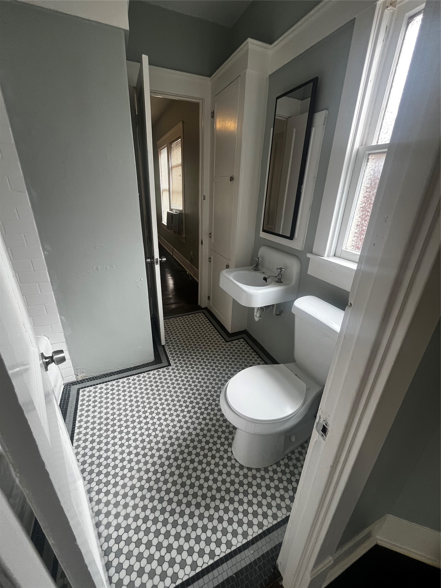 1711 West Main Street, Unit 3 Houston, TX 77098 - Photo 3 of 11 a bathroom with a toilet a sink and mirror