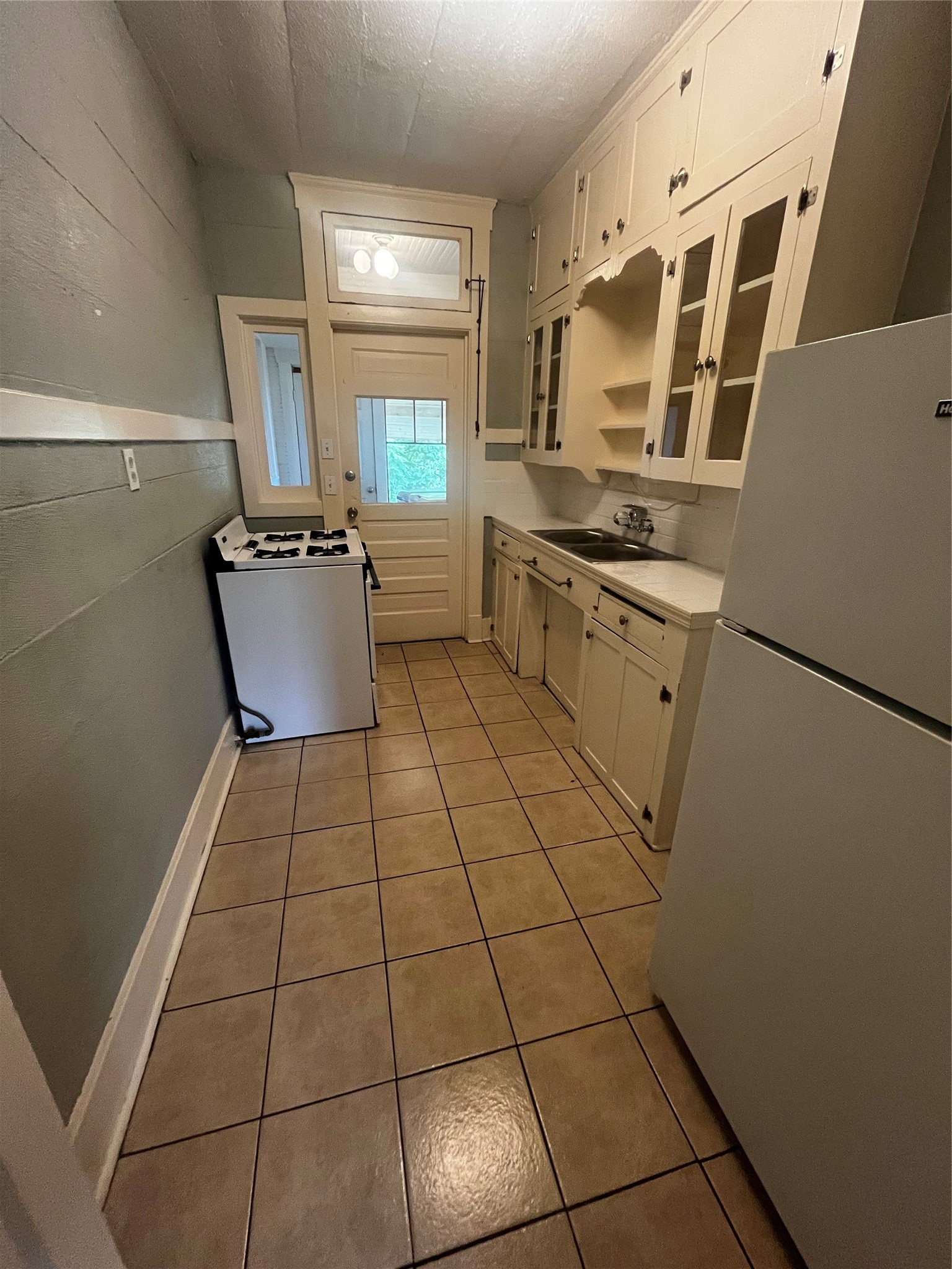 1711 West Main Street, Unit 3 Houston, TX 77098 - Photo 9 of 11 a kitchen with granite countertop a stove a sink and a refrigerator
