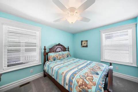 a bedroom with a large bed chandelier and a window