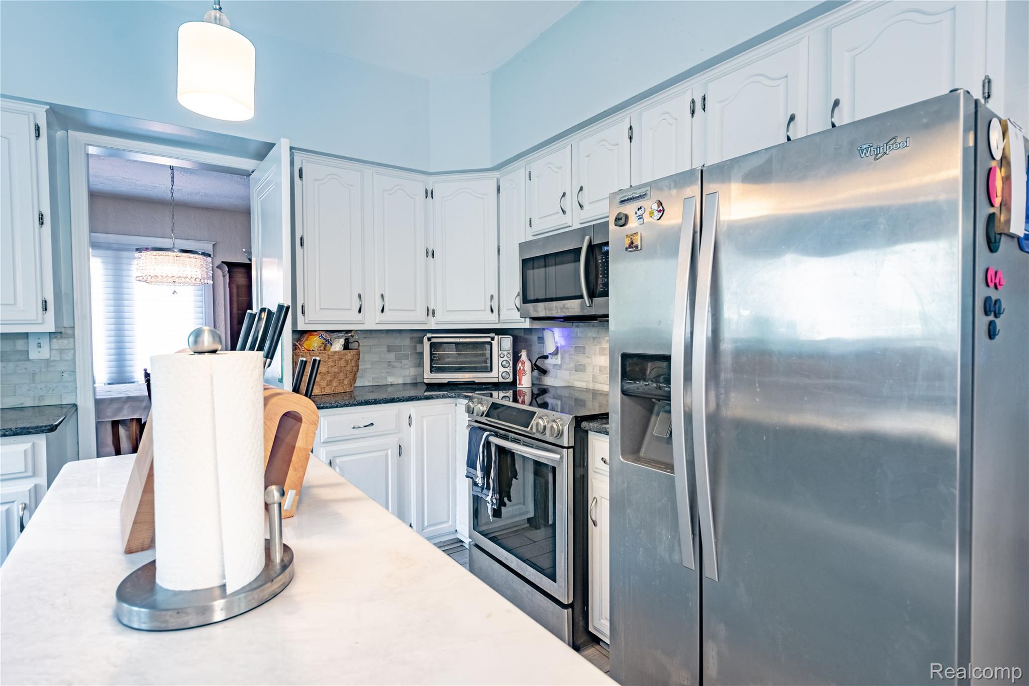 5630 Lakeshore Road Fort Gratiot, MI 48059 - Photo 19 of 49 Kitchen featuring white cabinetry, dark countertops, a tile backsplash, and stainless steel appliances