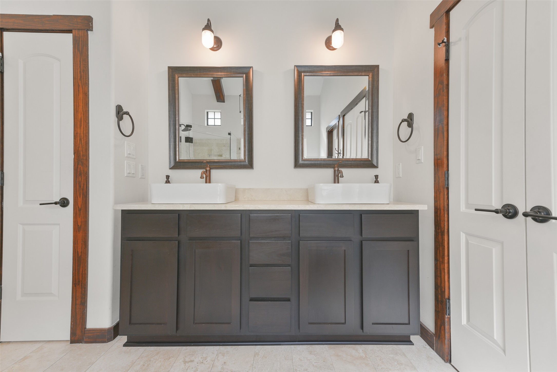 2601 Bevis Street, Unit B Houston, TX 77008 - Photo 16 of 25 Another view of the primary bath. The vanity offers dual vessel sinks, travertine countertops, decorative mirrors, vanity lights and ample storage. To the left is a linen closet.