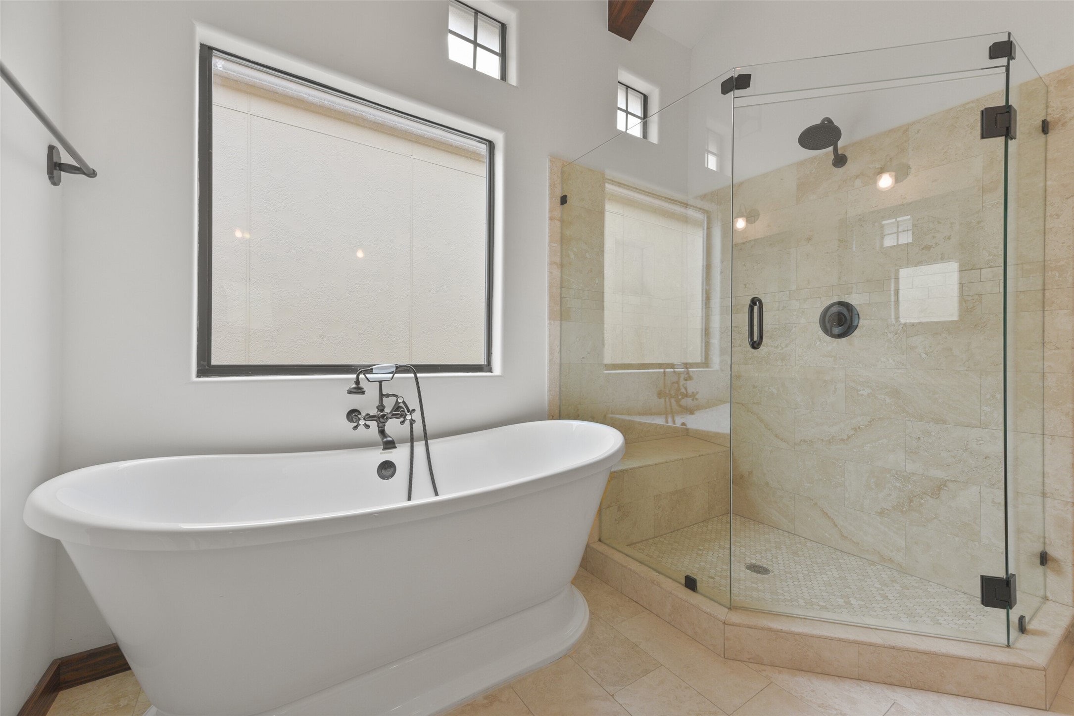 2601 Bevis Street, Unit B Houston, TX 77008 - Photo 17 of 25 Primary bath features a separate shower with frameless door, bench seat, and stunning travertine walls and floor. Enjoy a freestanding tub for ultimate relaxation.