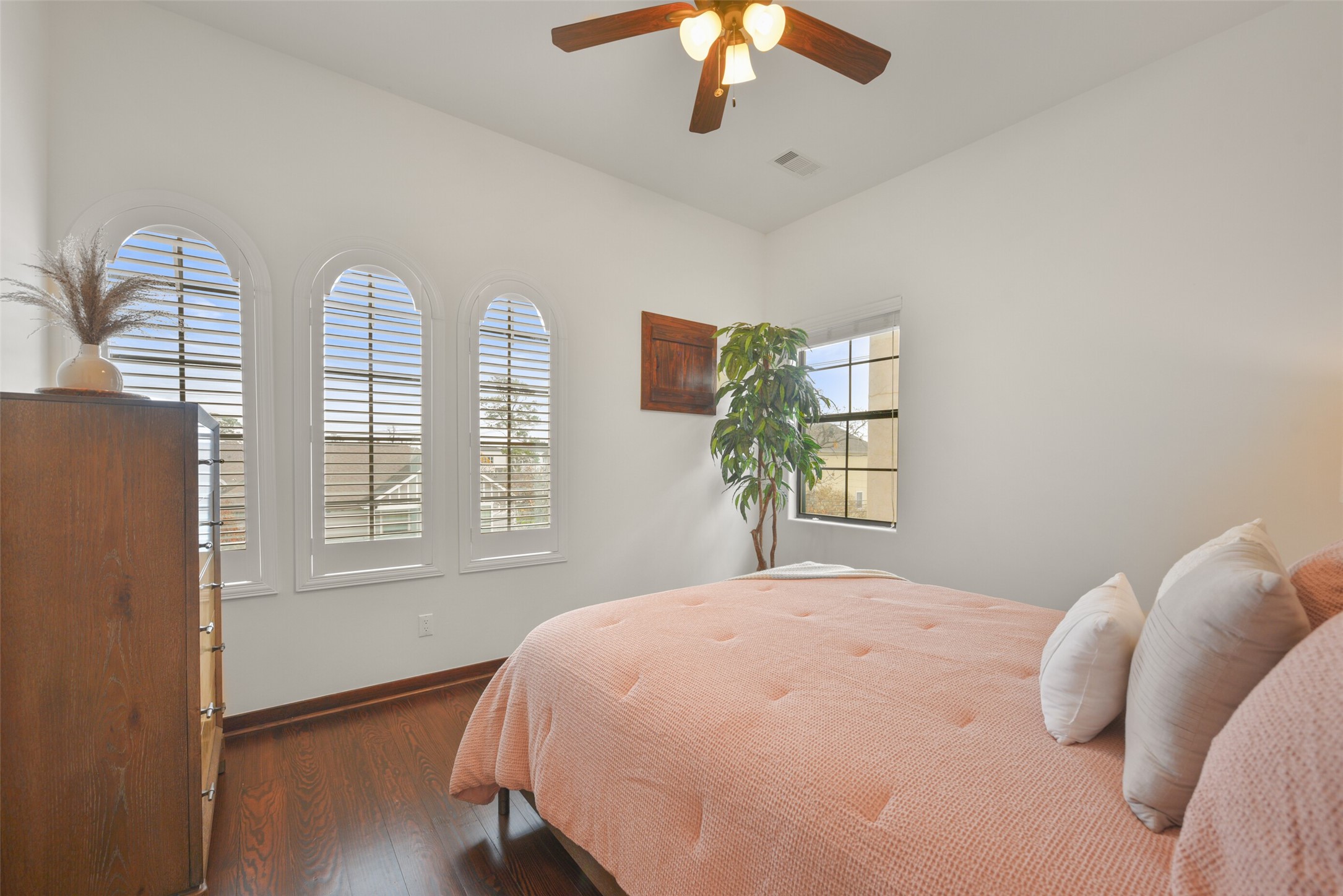 2601 Bevis Street, Unit B Houston, TX 77008 - Photo 18 of 25 Located on the 3rd floor with the primary bedroom, this spacious guest bedroom features a ceiling fan and windows with plantation shutters, providing comfort and privacy. Versatile in use, it’s perfect as a guest bedroom, study, or workout room.