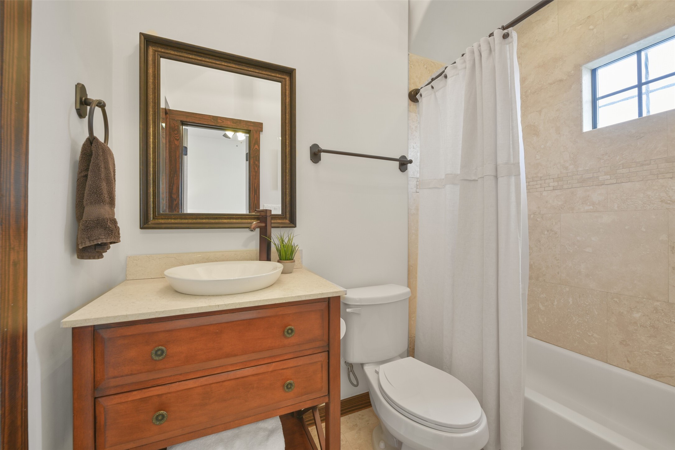 2601 Bevis Street, Unit B Houston, TX 77008 - Photo 19 of 25 Attached ensuite bathroom for the guest bedroom located on the 3rd floor features a tub/shower featuring elegant travertine shower walls. A decorative vanity with a vessel sink and a convenient closet complete the space.