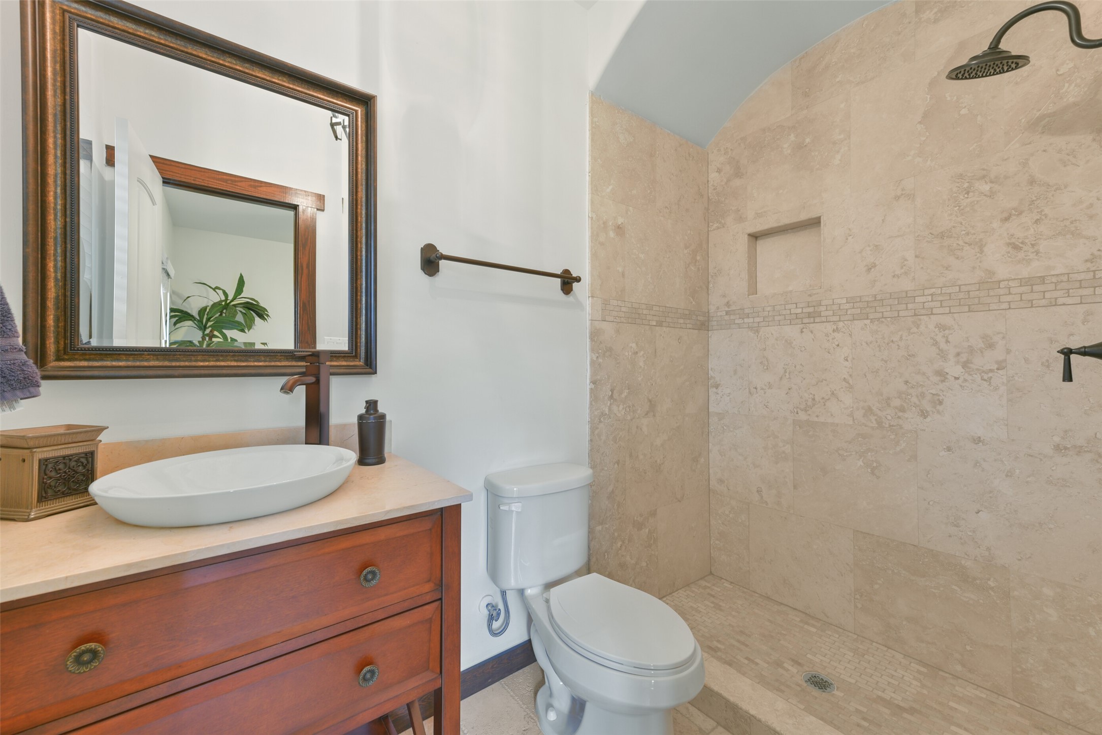2601 Bevis Street, Unit B Houston, TX 77008 - Photo 21 of 25 Ensuite bathroom for the guest bedroom on the 1st floor features a stylish shower w/ travertine walls and floor. A decorative vanity with a vessel sink adds a touch of elegance to this functional space.