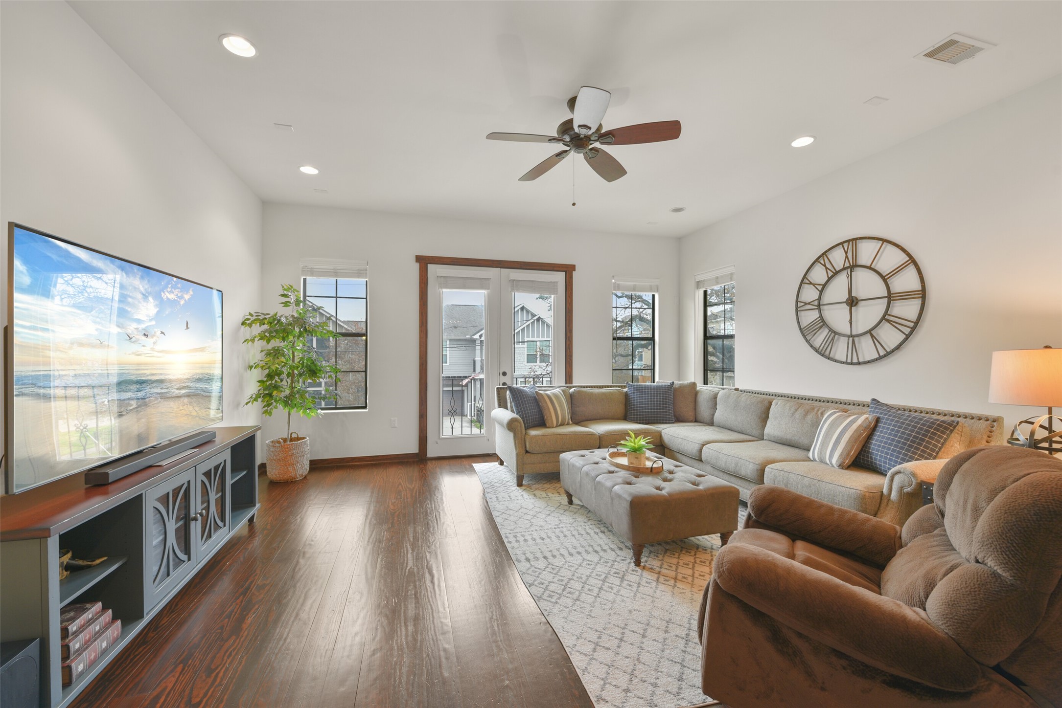 2601 Bevis Street, Unit B Houston, TX 77008 - Photo 3 of 25 Bright and spacious living/family room flooded with natural light. Featuring a ceiling fan for comfort and recessed can lighting for ambiance, this room is designed for relaxation and entertaining. French doors open to a charming Juliet balcony, offering a perfect spot to enjoy the view. Windows with blinds provide privacy and light control. Handscraped hardwood floors throughout the 2nd and 3rd floor, NO CARPET!