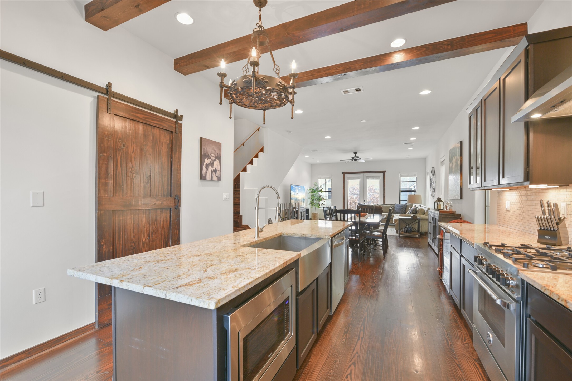2601 Bevis Street, Unit B Houston, TX 77008 - Photo 8 of 25 Top-of-the-line stainless steel appliances, including aBertazzoni 4-burner gas range and vent hood, Whirlpool French door refrigerator/freezer. Enjoy the convenience of a stainless steel farmhouse sink, Whirlpool dishwasher, built-in microwave, and a mini wine chiller. Ample cabinet space, under-cabinet lighting, and a spacious pantry with a stained wood sliding door complete the perfect culinary setup.