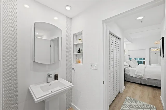 a view of storage and utility room with baby crib and wooden floor