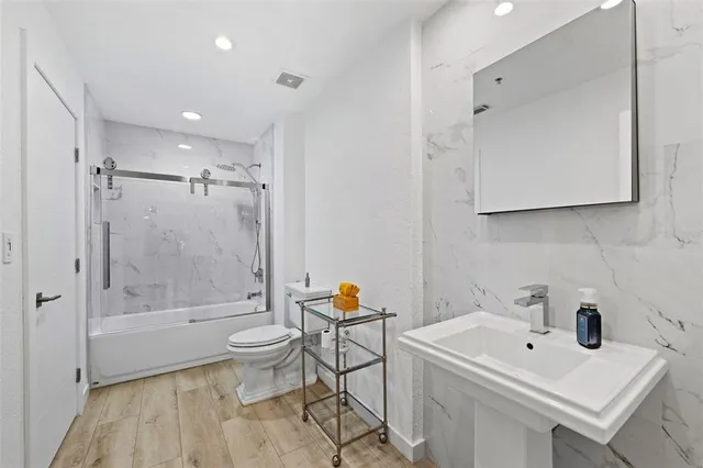a bathroom with a sink toilet and shower