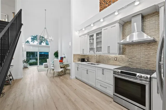 a kitchen with wooden floor stainless steel appliances and cabinets