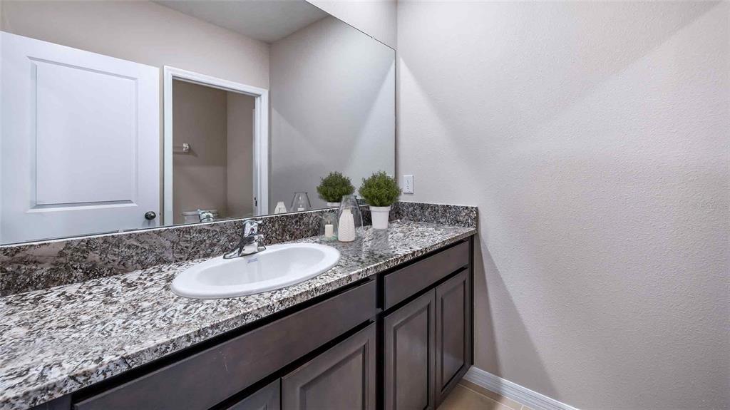 2191 Stratten Drive Zephyrhills, FL 33541 - Photo 14 of 16 a bathroom with a granite countertop sink and a mirror