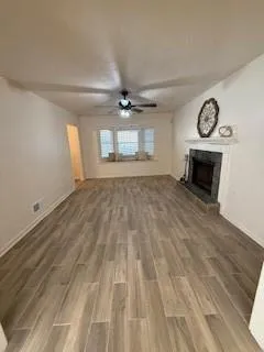 an empty room with windows and fireplace