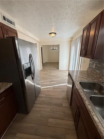 a view of kitchen with a sink and refrigerator