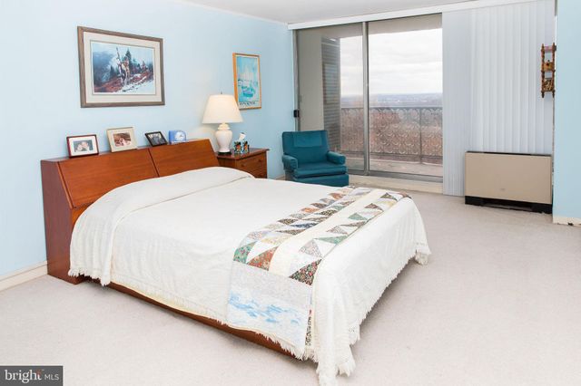 a spacious bedroom with a bed and a large window