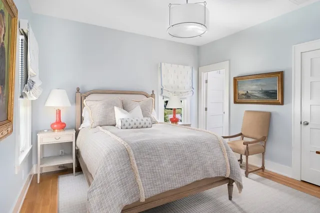 a large bed sitting in a bedroom next to a window with a dresser