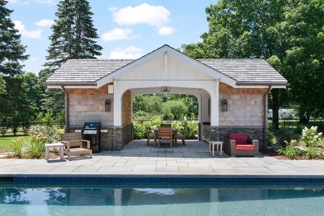 a view of a swimming pool with a patio and fire pit