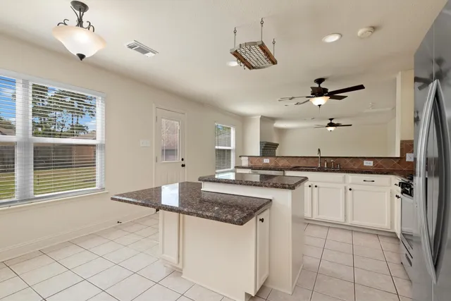 a kitchen with granite countertop cabinets a sink and appliances