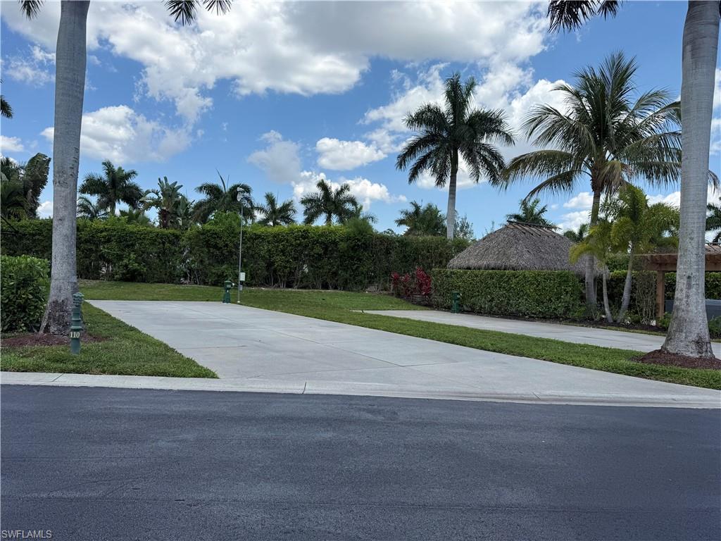 13594 Snapper Lane Naples, FL 34114 - Photo 2 of 29 a palm tree sitting in front of a house with a yard