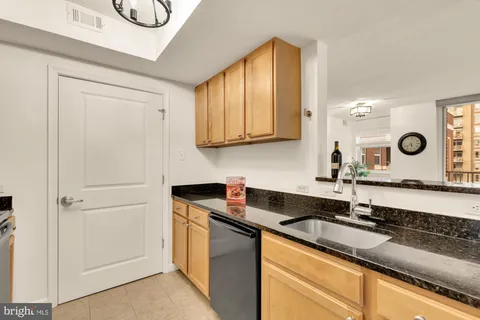 a kitchen with granite countertop a sink a stove and cabinets