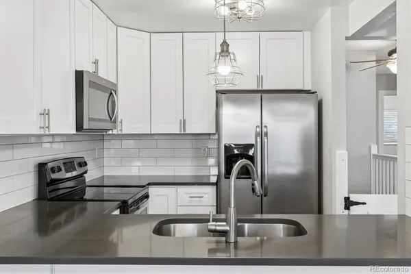 a kitchen with sink a refrigerator and cabinets