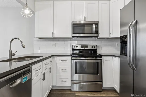 a kitchen with appliances a sink and cabinets