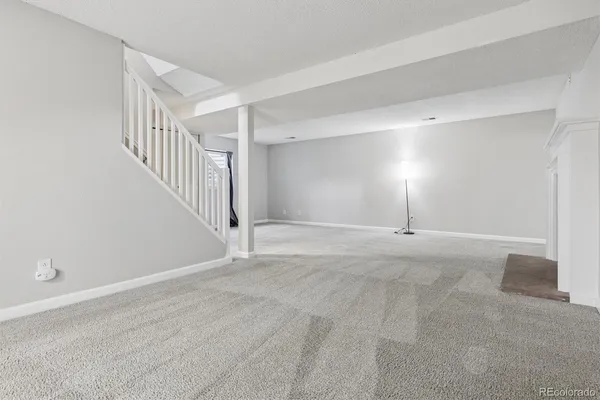 a view of an empty room with stairs and a window