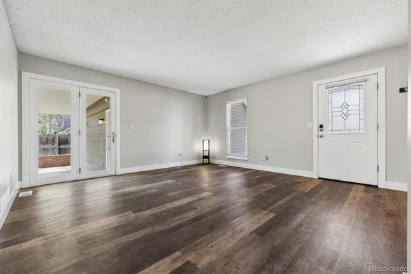 a view of empty room with wooden floor and window