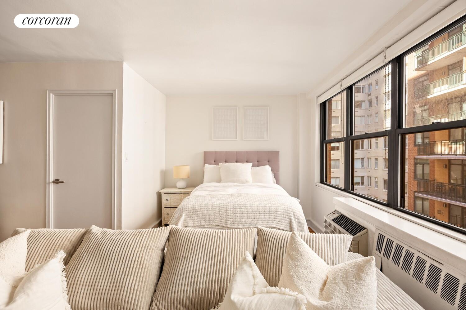 209 East 56th Street, Unit 7A Manhattan, NY 10022 - Photo 2 of 7 a bedroom with a bed and a large window