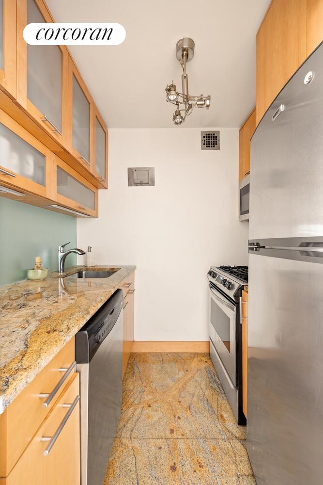 209 East 56th Street, Unit 7A Manhattan, NY 10022 - Photo 4 of 7 a kitchen with a sink a stove and a refrigerator