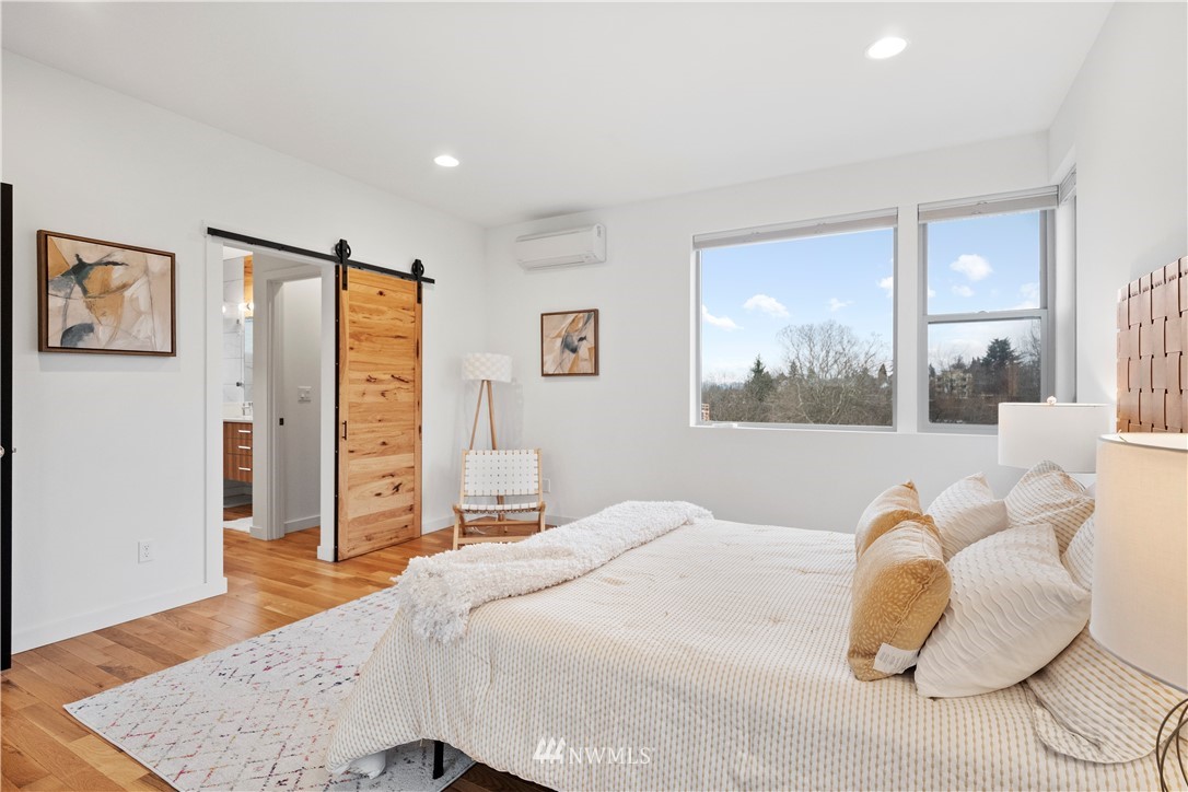 3932 South Brandon Street, Unit B Seattle, WA 98118 - Photo 21 of 29 a bedroom with a bed and wooden floor