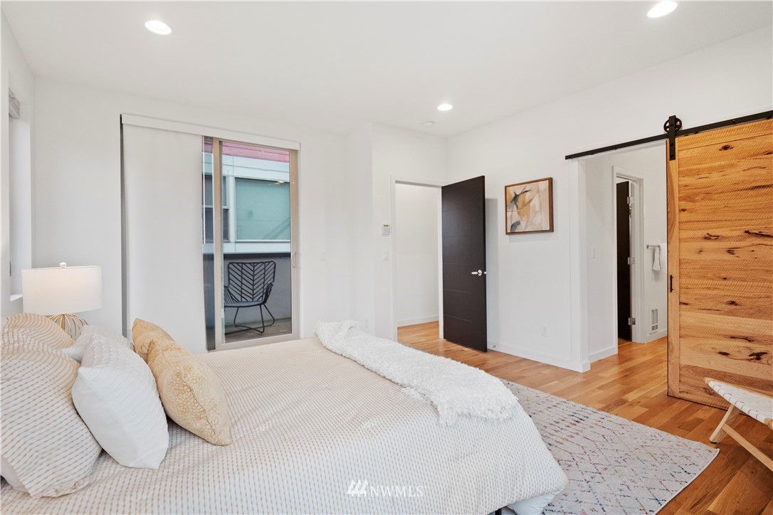 3932 South Brandon Street, Unit B Seattle, WA 98118 - Photo 22 of 29 a bedroom with a bed and wooden floor