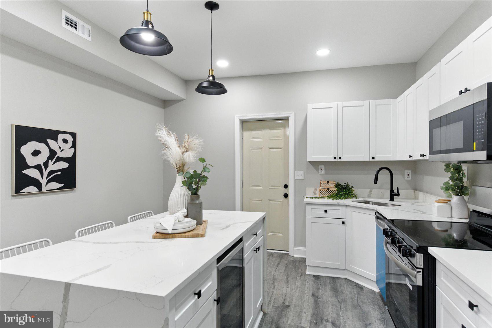 1607 Montpelier Street Baltimore, MD 21218 - Photo 11 of 37 a kitchen that has a lot of cabinets in it and wooden floors