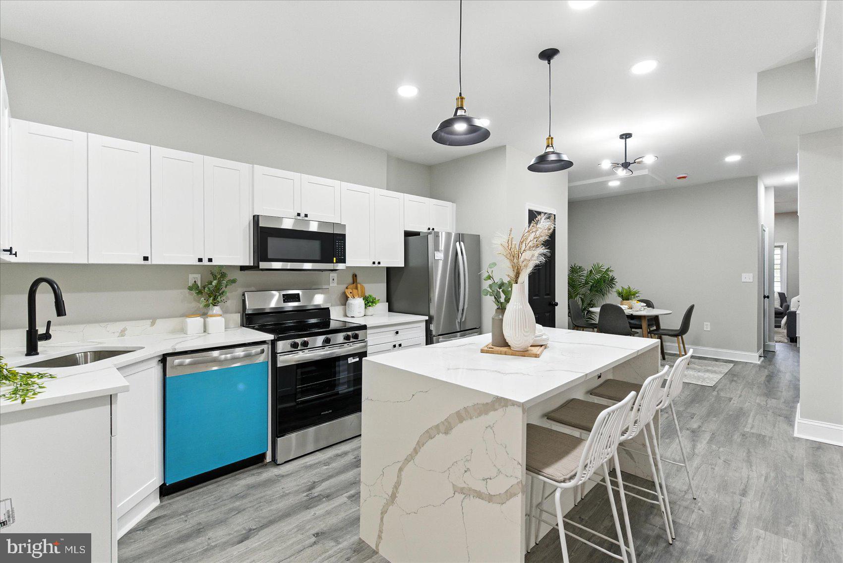 1607 Montpelier Street Baltimore, MD 21218 - Photo 16 of 37 a kitchen with a stove a sink a dining table and chairs