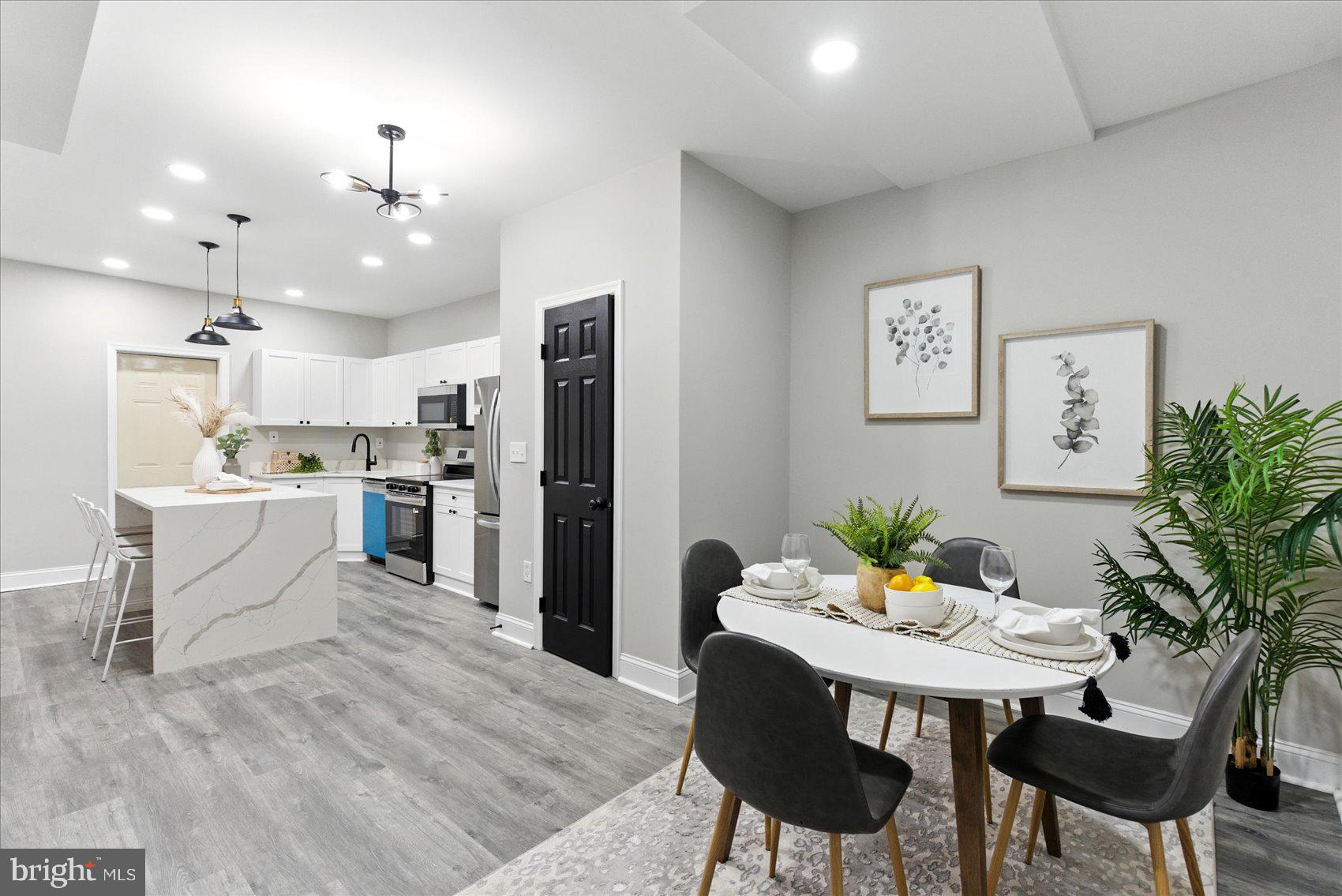 1607 Montpelier Street Baltimore, MD 21218 - Photo 6 of 37 a kitchen with stainless steel appliances kitchen island granite countertop a dining table chairs and refrigerator