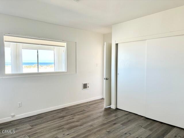 3289 Ocean Drive, Unit 3 Oxnard, CA 93035 - Photo 13 of 18 an empty room with wooden floor and windows