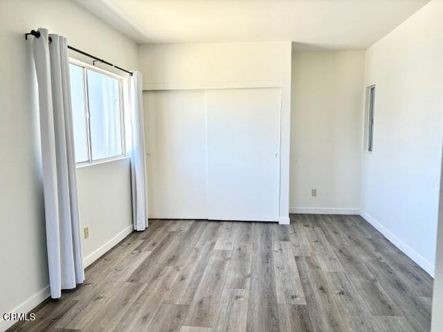 3289 Ocean Drive, Unit 3 Oxnard, CA 93035 - Photo 16 of 18 a view of an empty room with wooden floor and a window