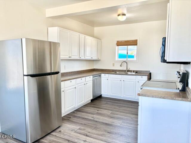 3289 Ocean Drive, Unit 3 Oxnard, CA 93035 - Photo 8 of 18 a kitchen with white cabinets sink and refrigerator