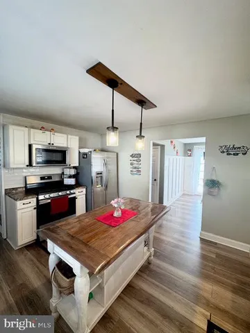 a kitchen with kitchen island white cabinets and stainless steel appliances