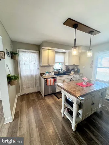 a kitchen with a stove a chimney a refrigerator and cabinets
