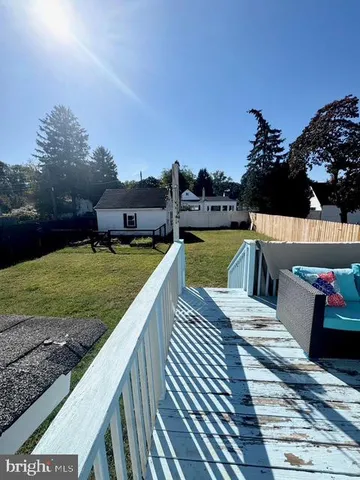 a view of a roof deck with couches and wooden floor
