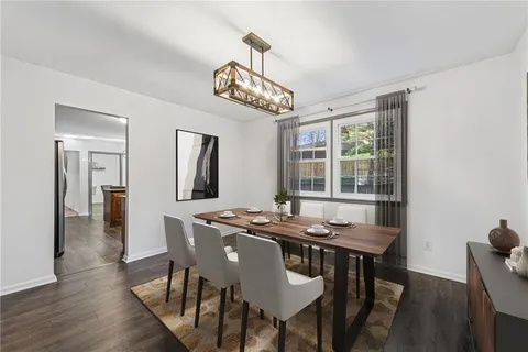 a view of a dining room with furniture a chandelier and wooden floor