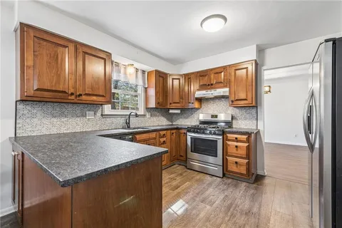 a kitchen with stainless steel appliances granite countertop a stove a sink and a microwave