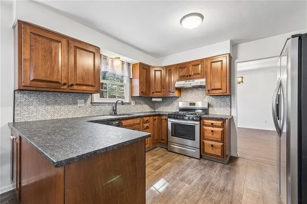 a kitchen with stainless steel appliances granite countertop a stove a sink and a microwave