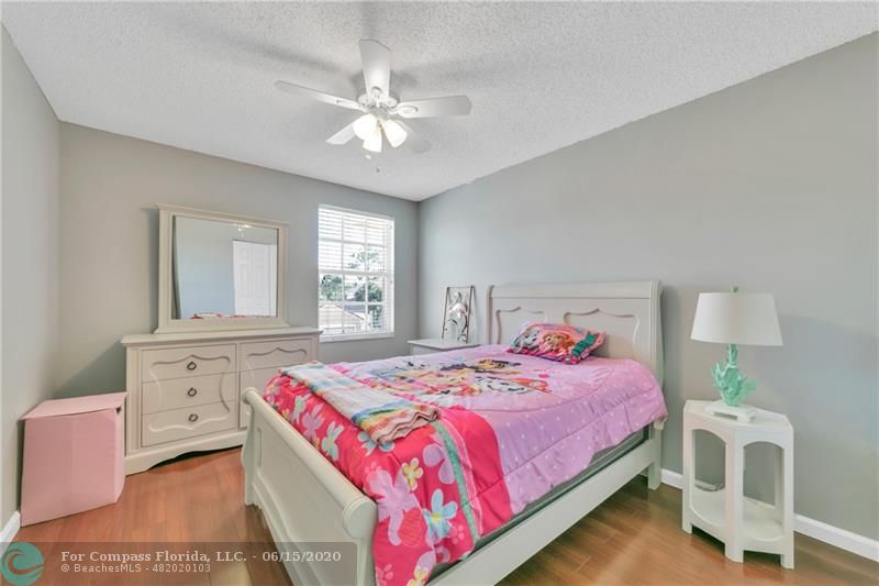 7680 Belmonte Boulevard Margate, FL 33063 - Photo 19 of 30 a bedroom with a bed and a chandelier