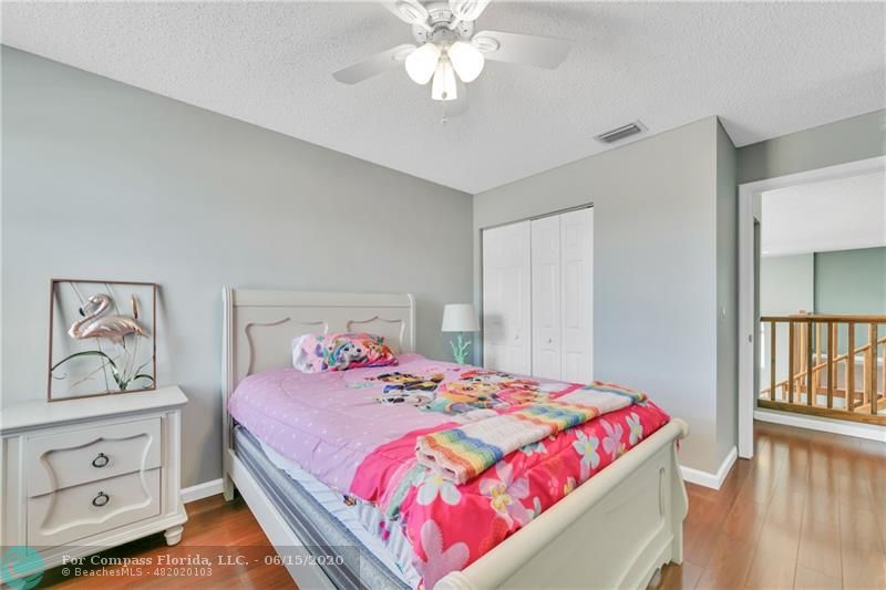 7680 Belmonte Boulevard Margate, FL 33063 - Photo 20 of 30 a bedroom with a bed and a chandelier